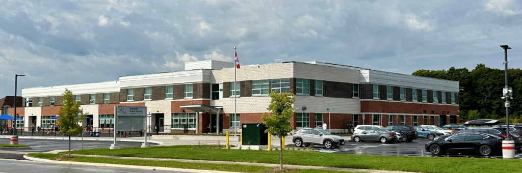 A large brick building with several cars parked in front of it.